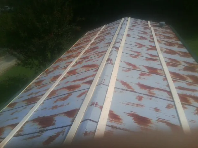 Rusted metal roof panels with new wood purlins before replacement — Storm Damage Roof Repair in Breezewood by Roofing Brothers