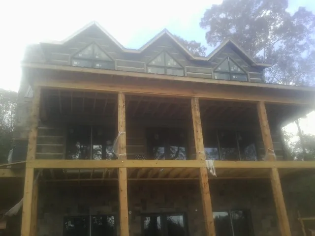 Dormers and porch framing on a large log home under construction — Roof Coating work by our crew in Breezewood