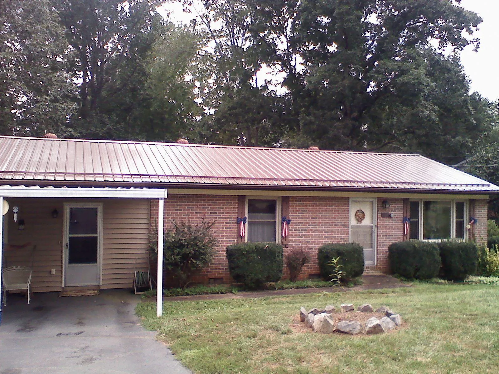 Bronze metal roof and carport on a brick ranch home — Roof Repair work by our crew in Breezewood